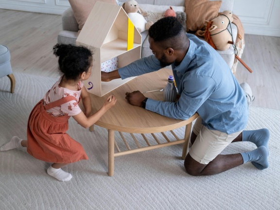 Adult and child with toy house